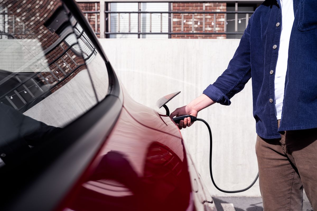 Person using charger to recharge Model Y vehicle