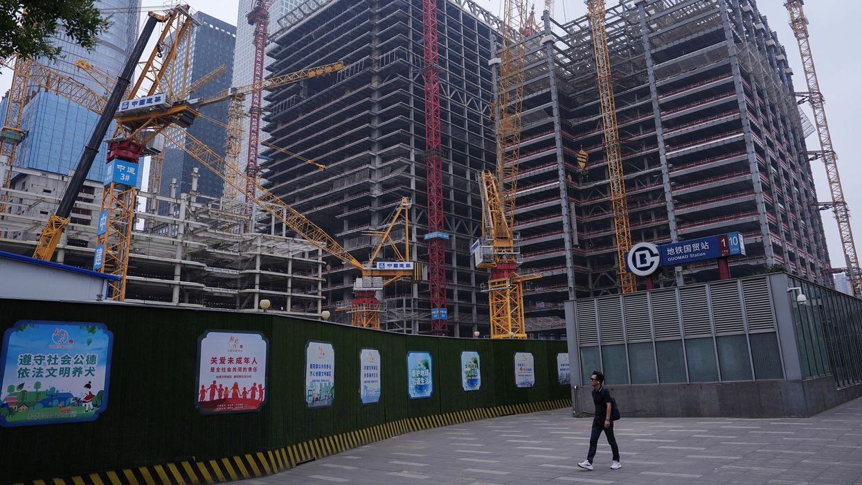 Person walks past a construction site in Beijing's Central Business District (CBD)