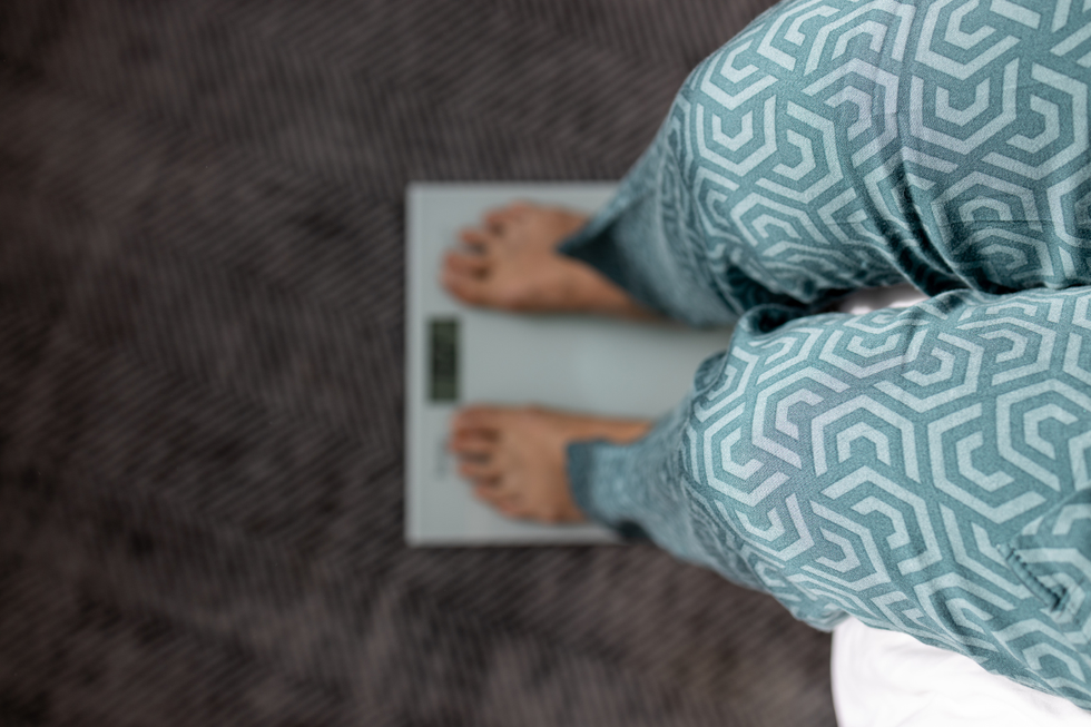 Person weighing themselves on scales