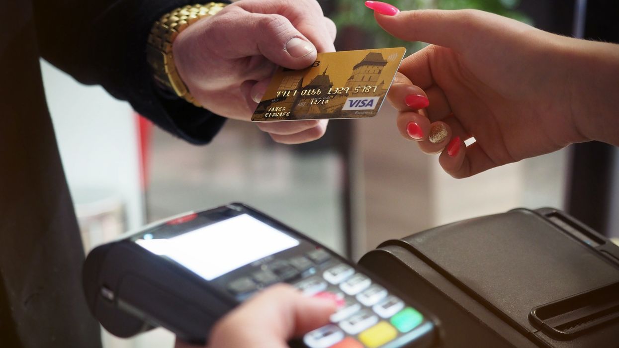 Person with debit card and card payment reader