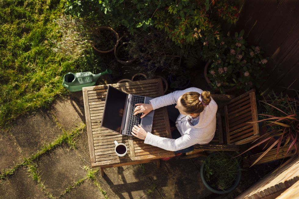 Person works from home in garden on sunny day
