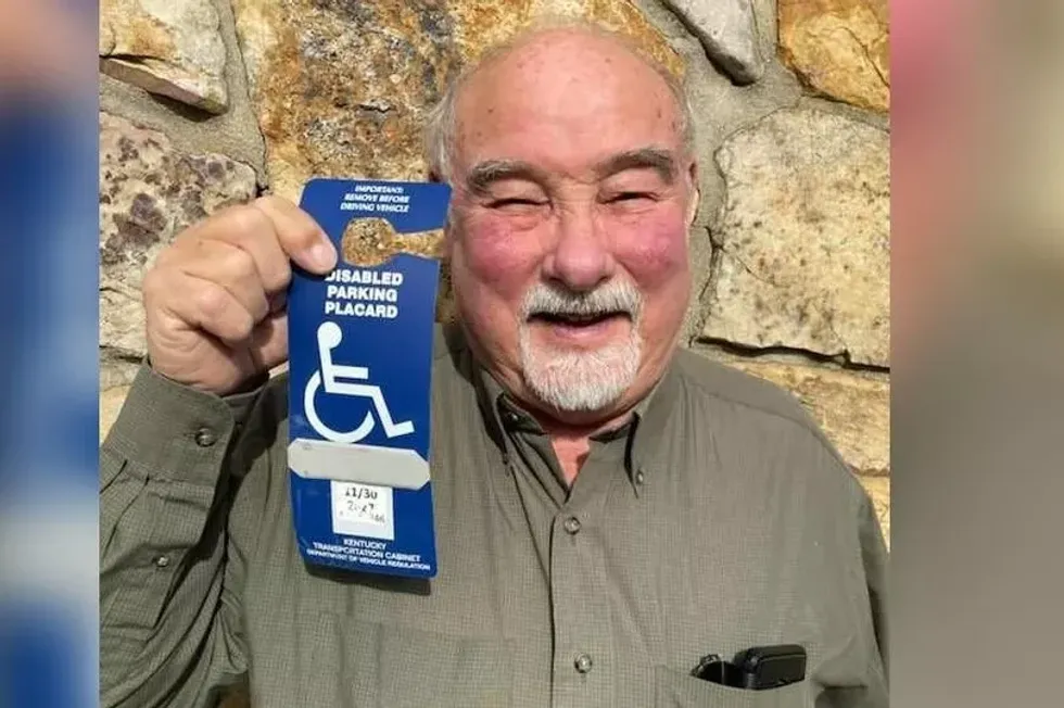 Peter Cox pictured holding the disability tag he displayed when he visited Liverpool