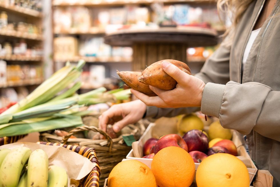 Picking up vegetables in grocery store