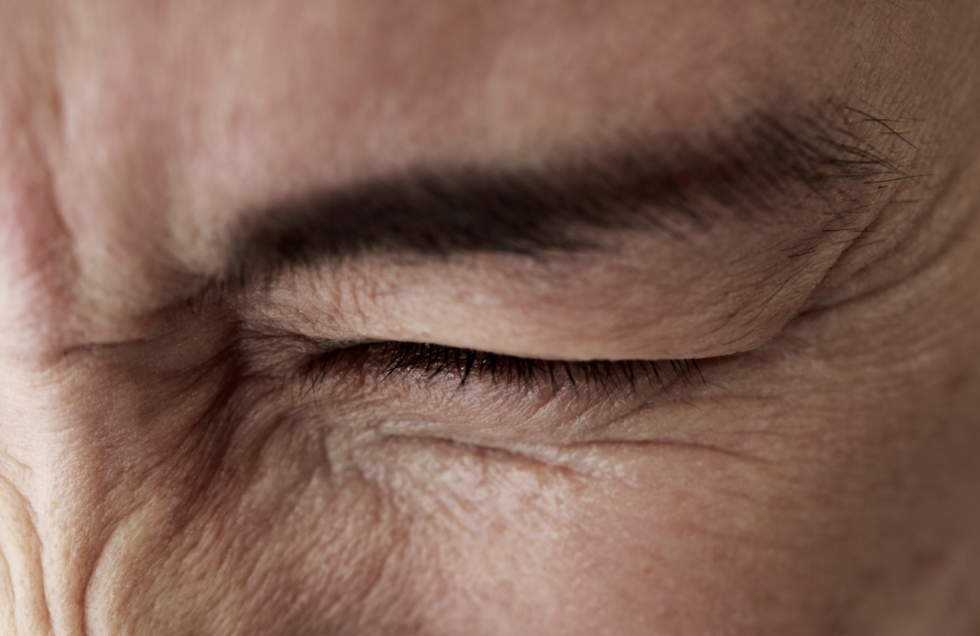 Picture of a man squinting his eyes out of pain
