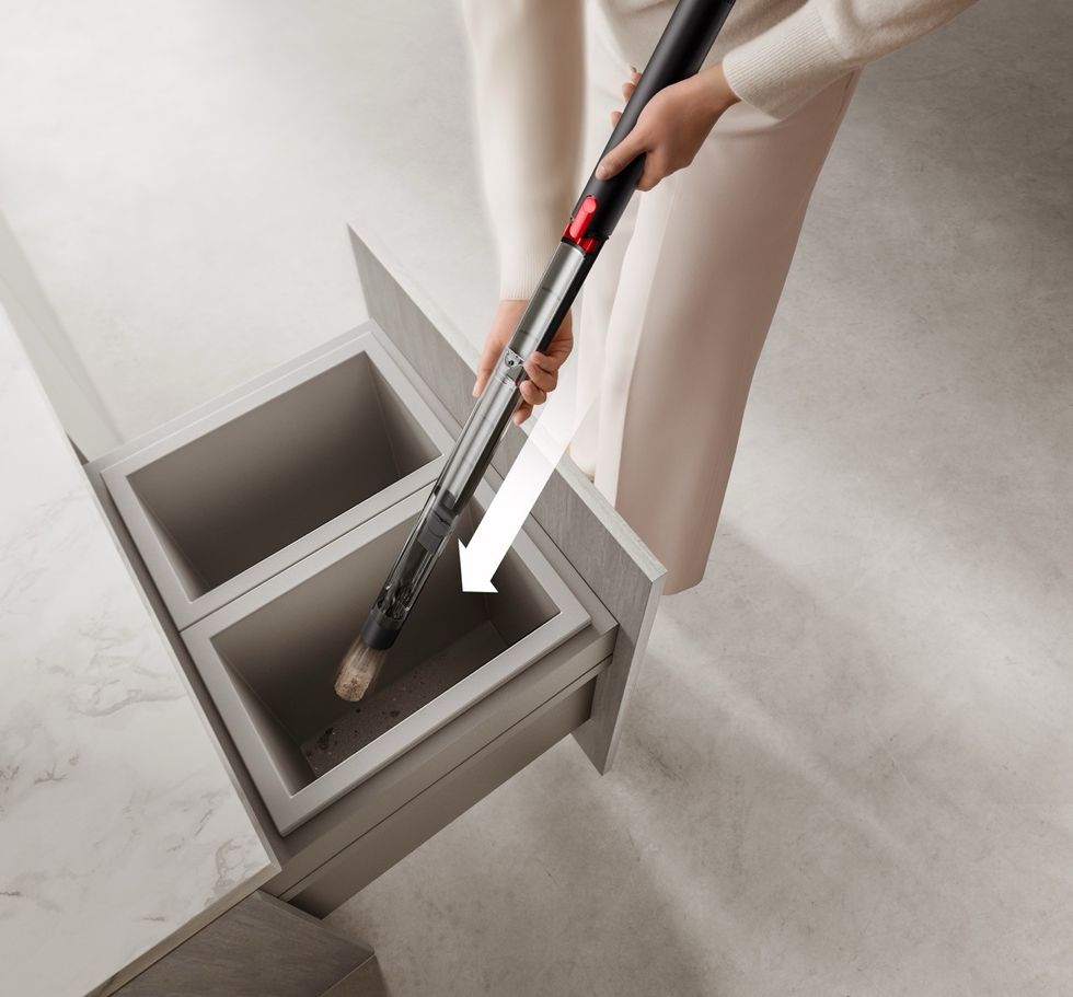 picture of a woman emptying the dyson pencilvac into the bin