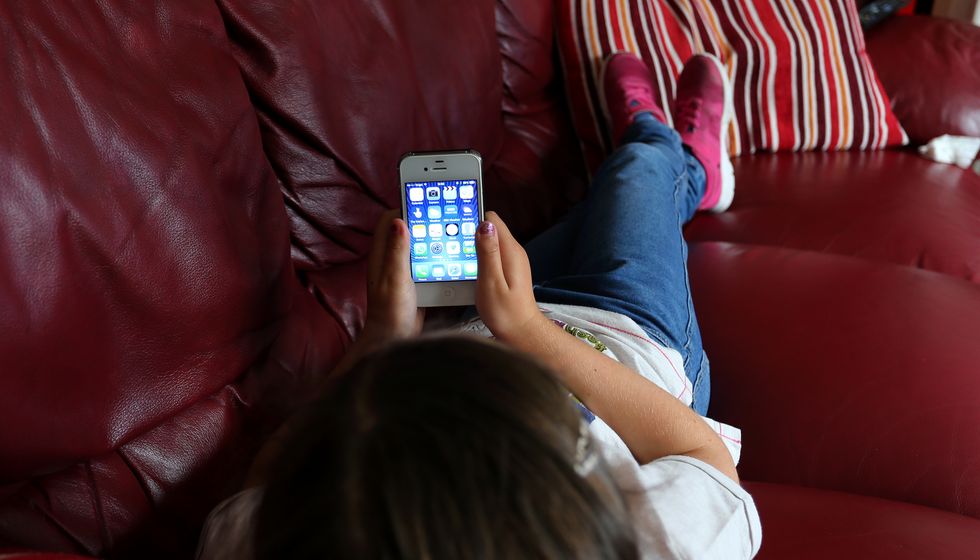 PICTURE POSED BY A MODEL File photo dated 21/08/14 of a child using an Apple iPhone smartphone. Blue light from phones and tablets may alter hormone levels and increase the risk of early puberty in children, early research suggests. Issue date: Friday September 16, 2022.