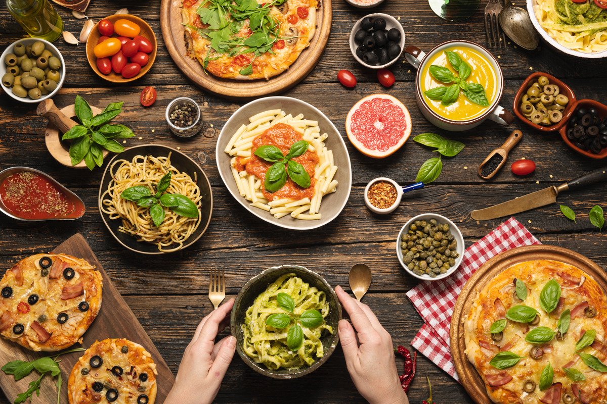 Pizza, pasta and bread laid out on a table