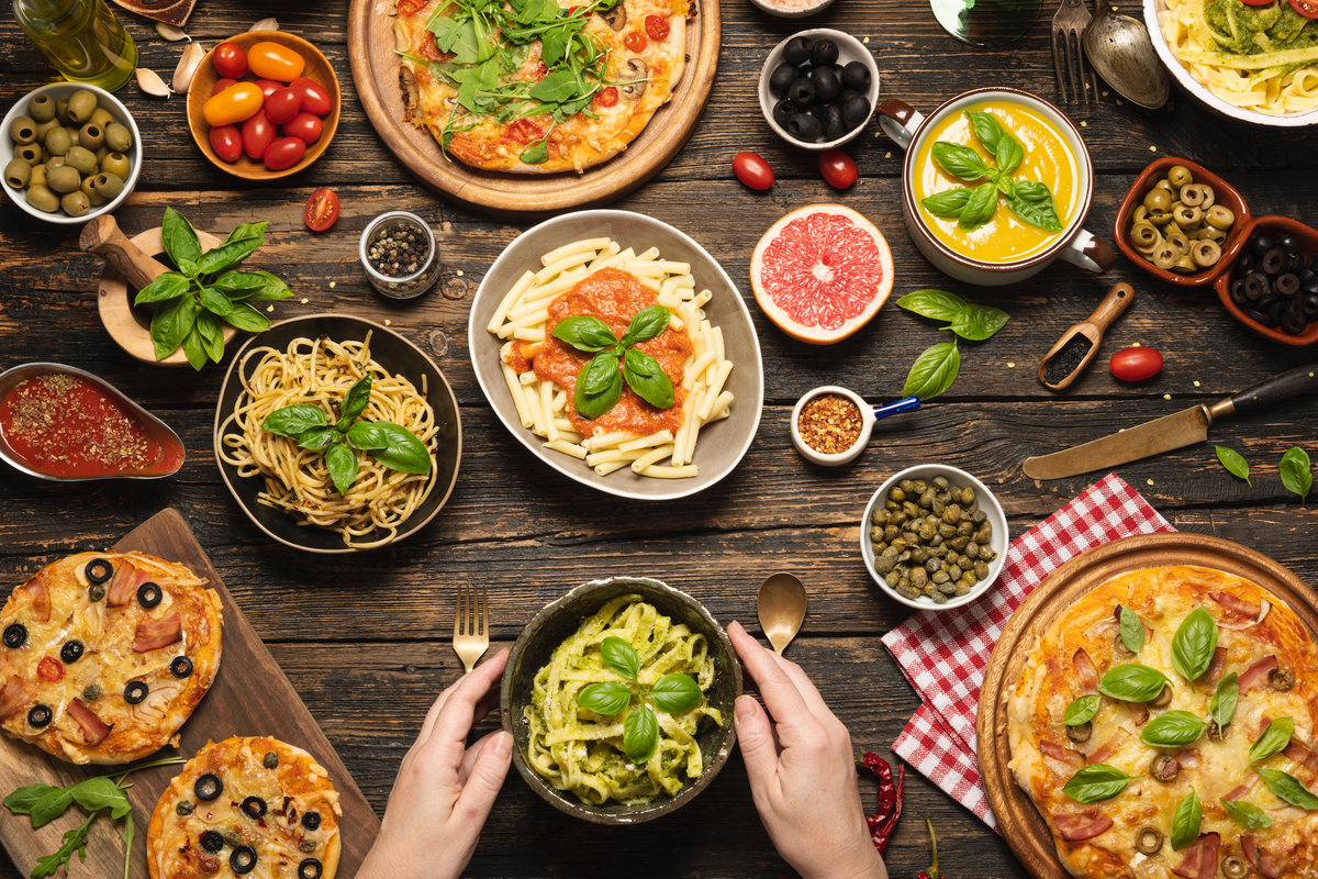 Pizza, pasta and bread laid out on a table 