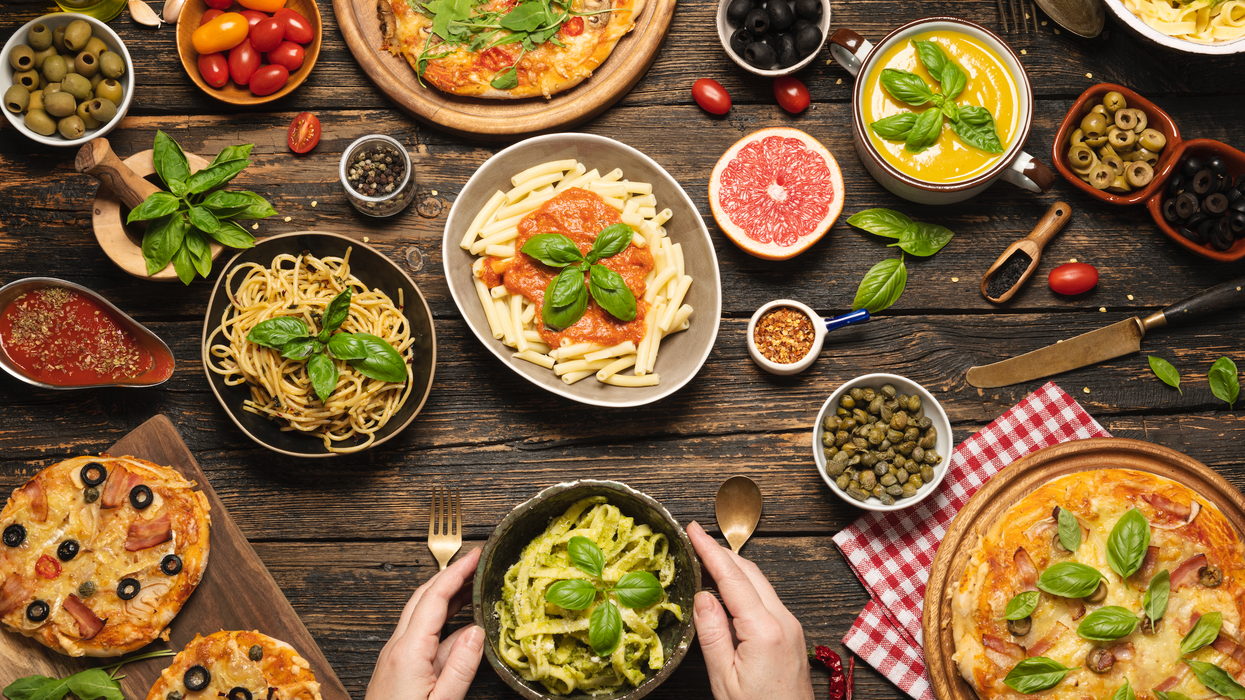 Pizza, pasta and bread laid out on a table