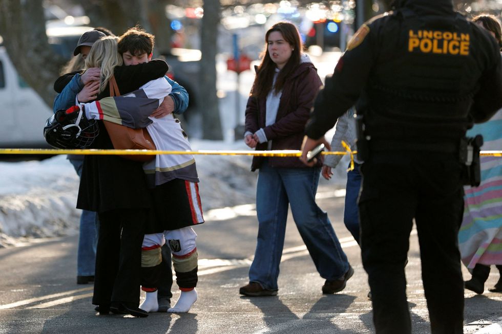 Players and spectators hug outside the ice rink as police cordon off the scene
