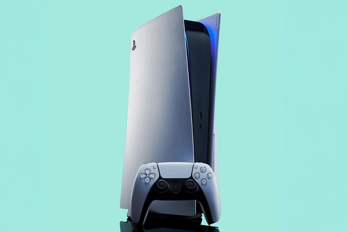 playstation 5 console with a controller propped up infront of it pictured against a turquoise background 