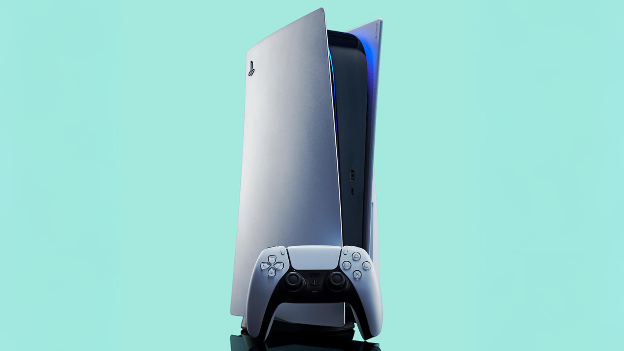 playstation 5 console with a controller propped up infront of it pictured against a turquoise background