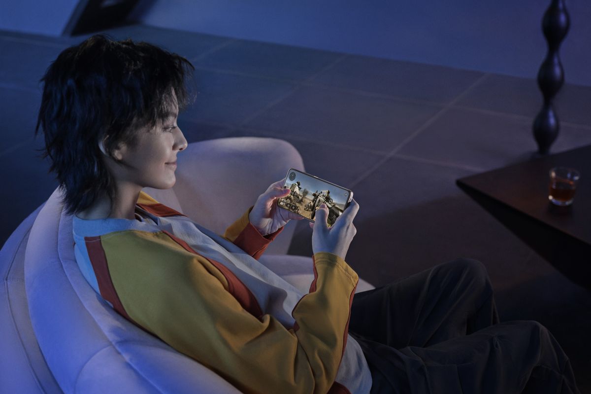 poco x7 in the hands of a player in a chair playing a mobile FPS shooter