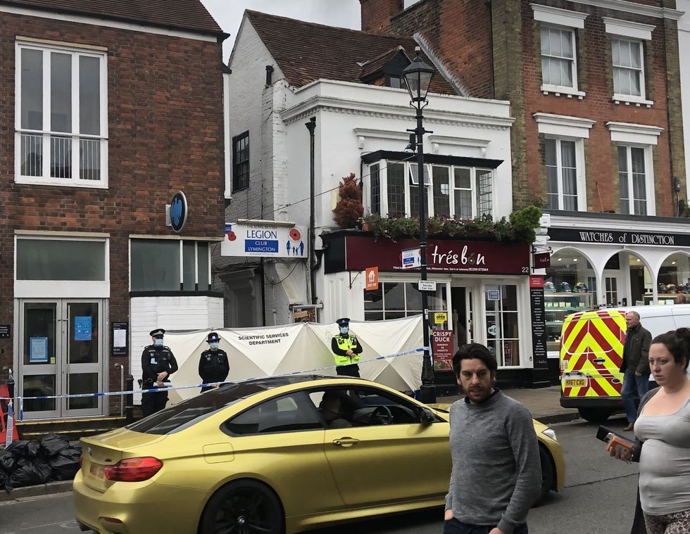 Police at the scene outside the Royal British Legion on High Street in Lymington, Hampshire, where two men and a woman were found with stab wounds on Friday. Picture date: Saturday October 23, 2021.