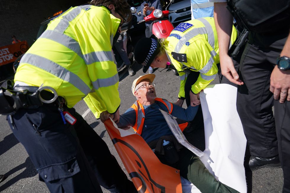 Police detain a Just Stop Oil activist during a slow walk protest in Vauxhall, central London