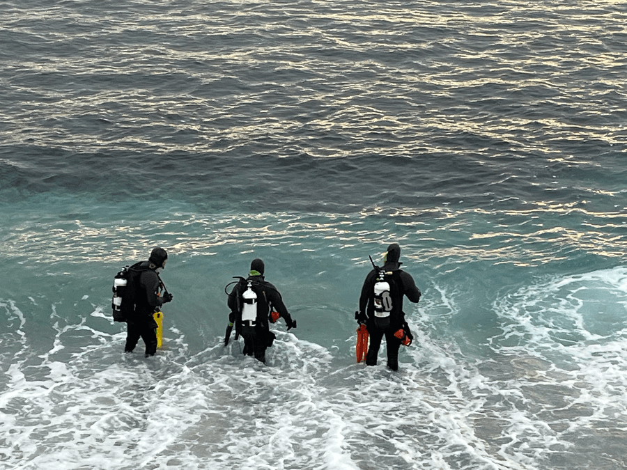 Police divers wade into the sea off Lovers Point