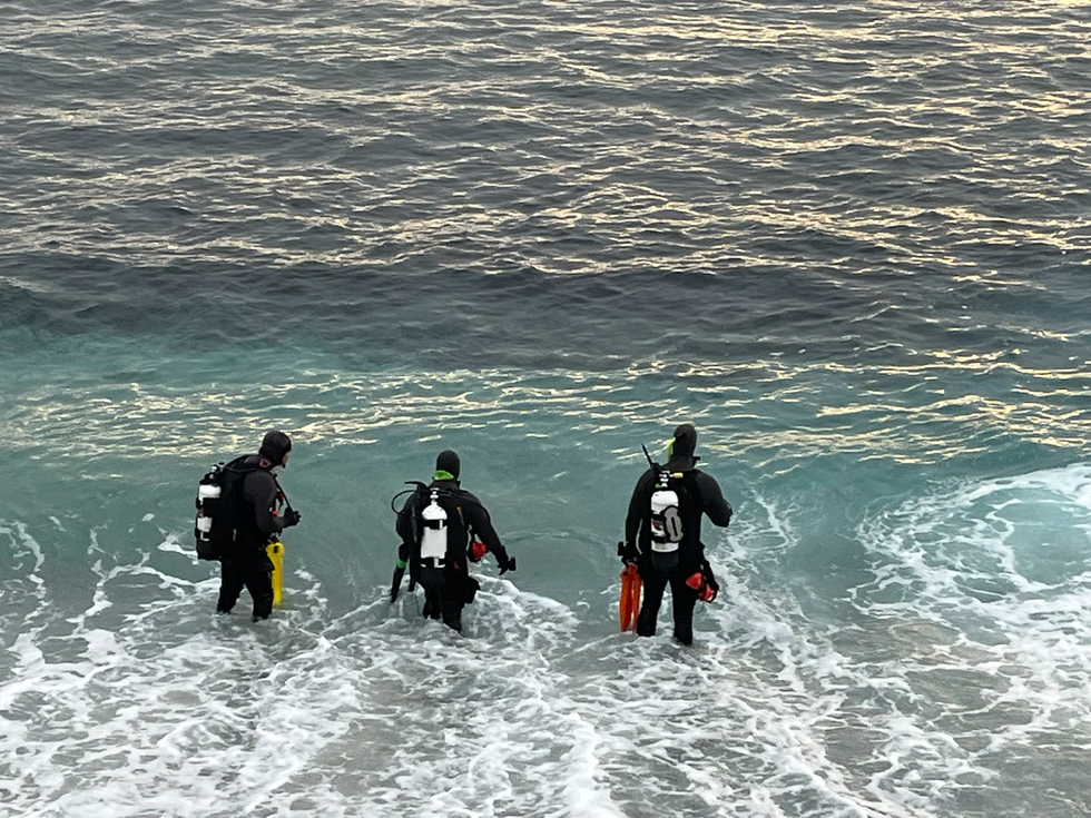 Police divers wade into the sea off Lovers Point