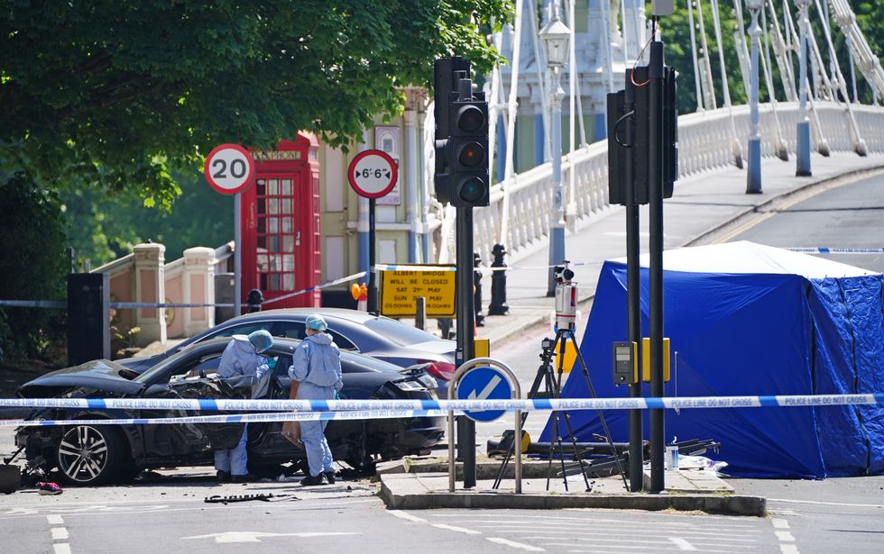 Police forensic officers at the scene at Cheyne Walk in Chelsea, London, after a 41-year-old woman and three dogs have been killed following a car crash. The driver of the car, a 26-year-old man, has been arrested on suspicion of causing death by dangerous driving and taken into custody. Picture date: Saturday May 14, 2022.