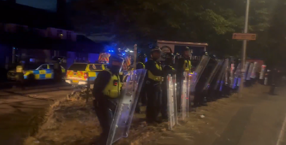 Police gather outside the Epping migrant hotel