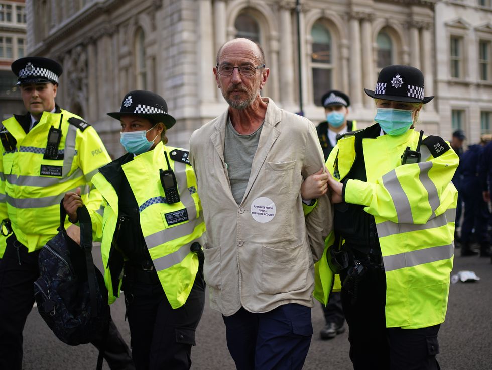 Police lead away a demonstrator during a protest by members of Extinction Rebellion