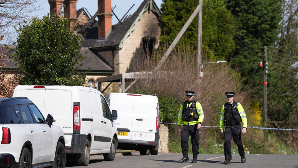 Police next to burnt-out station house