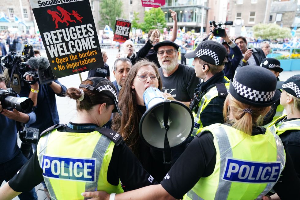 Police officer talk with protesters outside Perth Concert Hall
