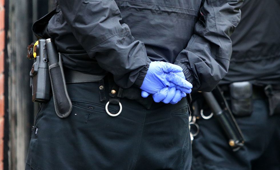 Police officer with hands behind his back