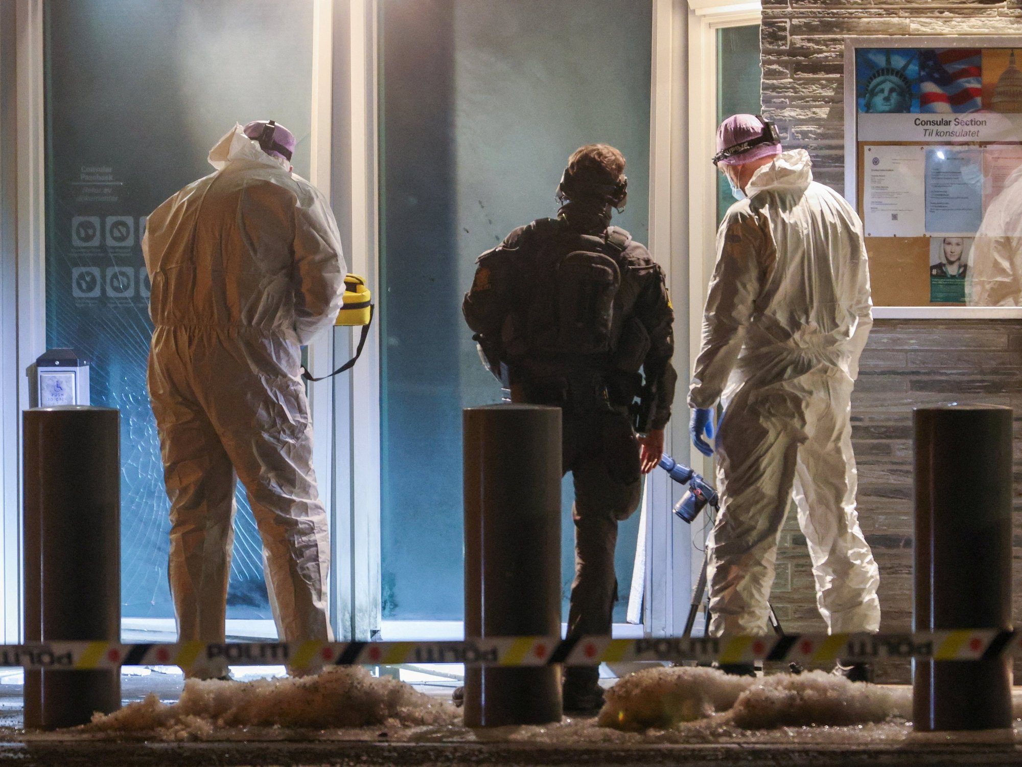 Police officers and technicians inspect the American embassy after a loud bang was reported at the site, in Oslo,