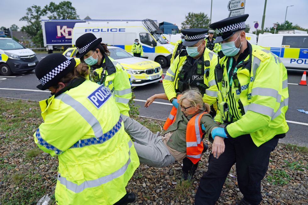 Police officers carry away a protester who had glued themselves to the highway at a slip road at Junction 4 of the A1(M), where climate activists carried out a further action after demonstrations which took place last week across junctions in Kent, Essex, Hertfordshire and Surrey.