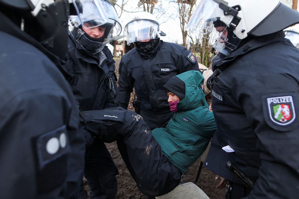 Police officers detain an activist during a sit-in protest against the expansion of the Garzweiler open-cast lignite mine of Germany's utility RWE, in Luetzerath, Germany, January 11, 2023 that has highlighted tensions over Germany's climate policy during an energy crisis. REUTERS/Thilo Schmuelgen