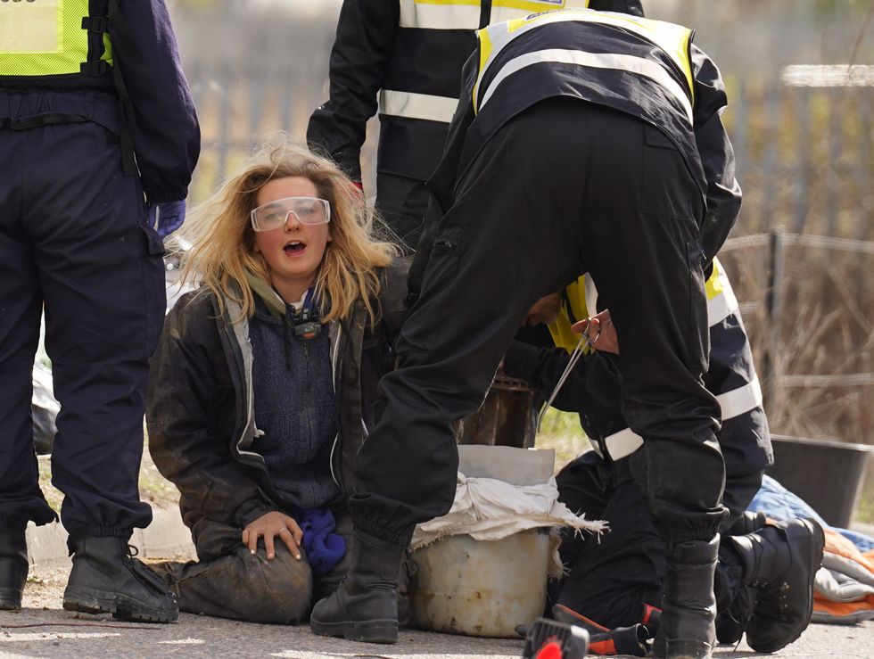 Police officers from the Protester Removal Team work to free a Just Stop Oil activist who is part of a blockade at the Tritan Truck Park in Grays, Essex.