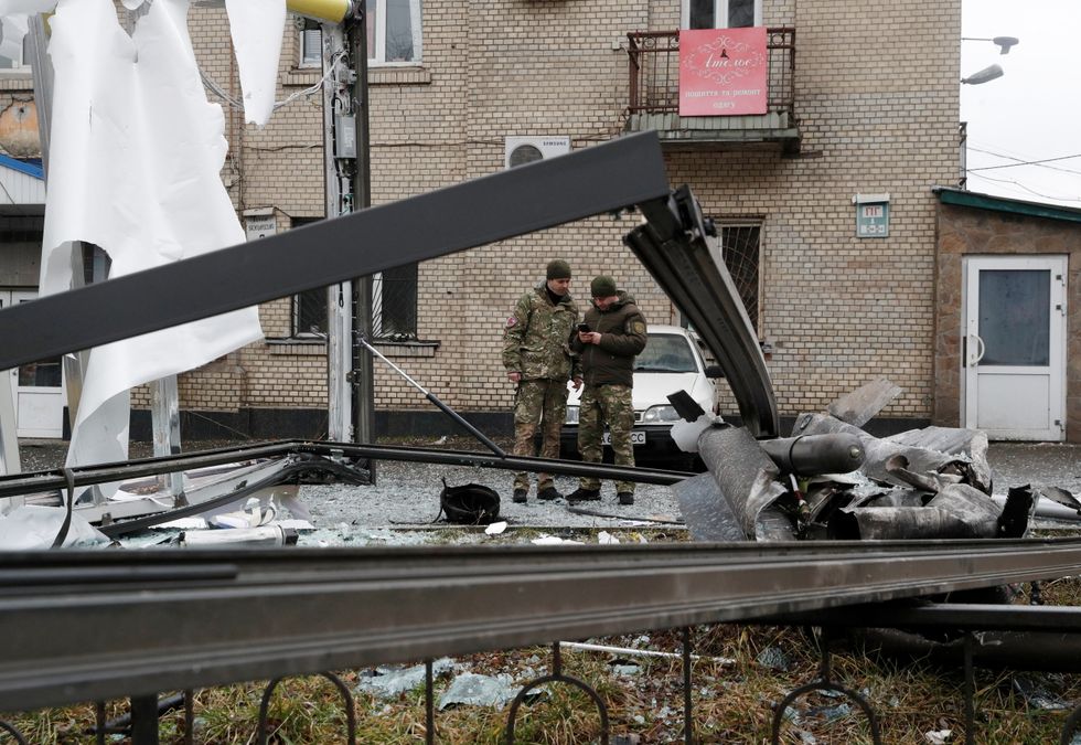 Police officers inspect the remains of a missile that fell in the street, after Russian President Vladimir Putin authorised a military operation in eastern Ukraine, in Kyiv, Ukraine February 24, 2022. REUTERS/Valentyn Ogirenko