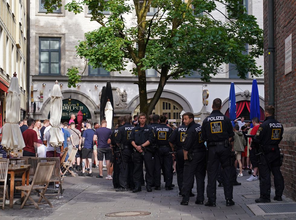 Police officers keep a watch on England football fans gathered outside Kilians Irish Pub in Frauenplatz square in Munich, ahead of the Germany v England UEFA Nations League game. Picture date: Monday June 6, 2022.