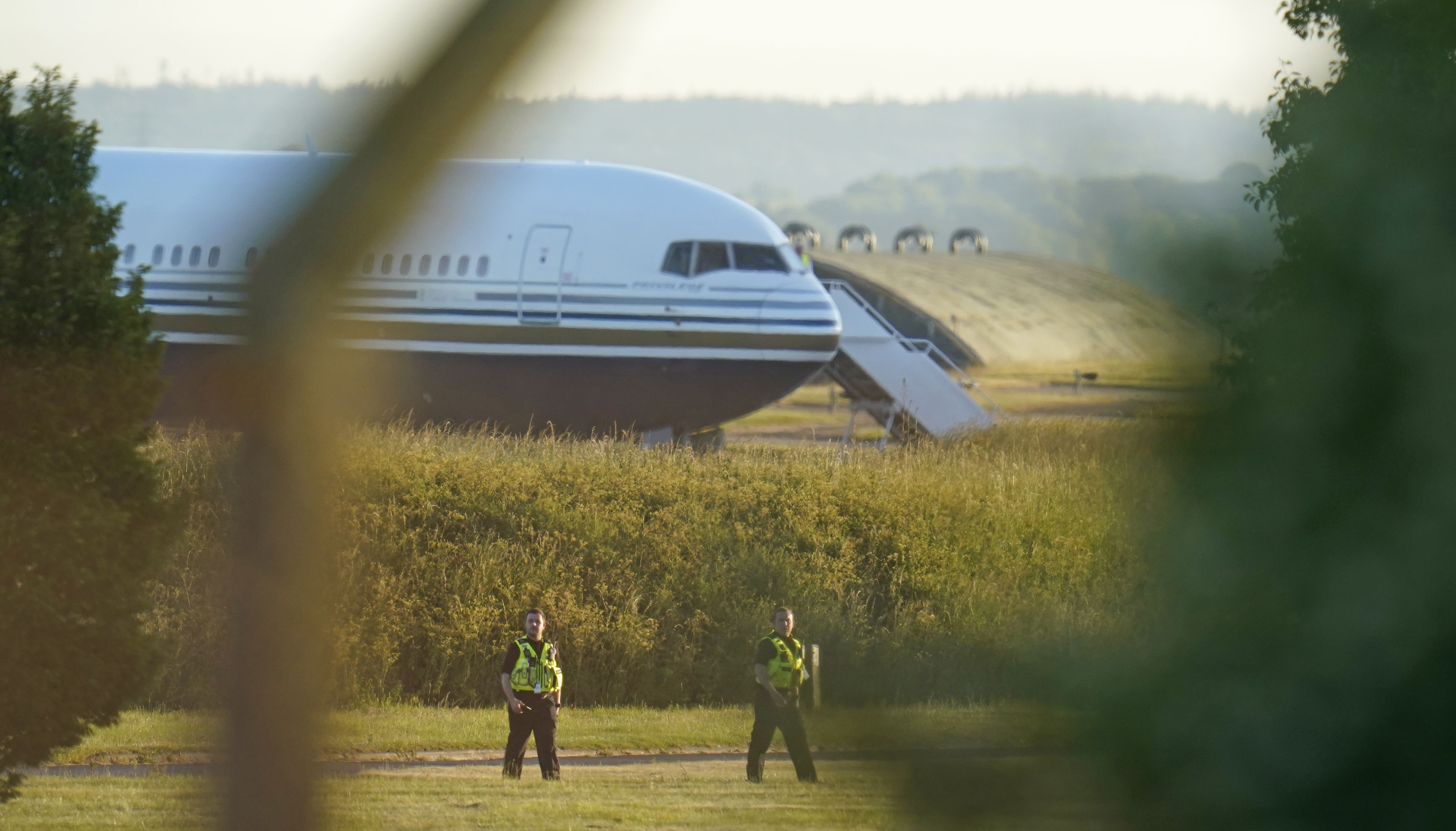 Police officers near a Boeing 767 aircraft at MoD Boscombe Down, near Salisbury, which is believed to be the plane set to take asylum seekers from the UK to Rwanda. Picture date: Tuesday June 14, 2022.