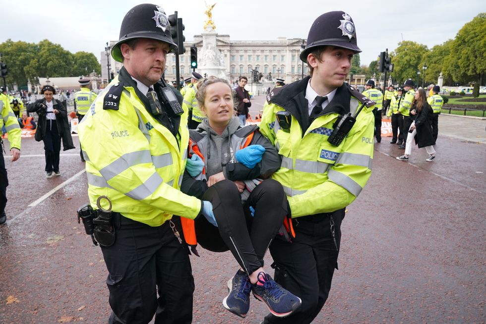 Police officers remove a campaigner from a Just Stop Oil protest on The Mall, near Buckingham Palace, London. Activists have been blocking roads in central London since the start of October as part of their campaign to stop future gas and oil projects from going ahead. Picture date: Monday October 10, 2022.