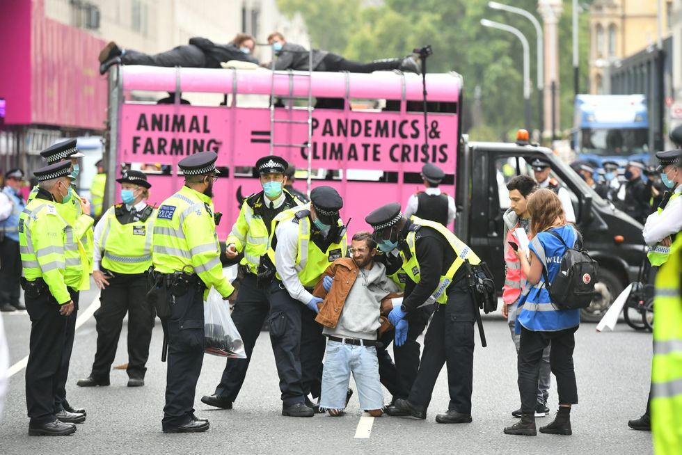 Police officers remove an Extinction Rebellion protester