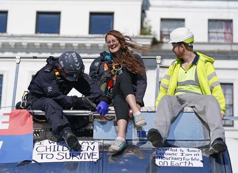 Police officers remove two protesters from the top of a tanker, as Insulate Britain block the A20 in Kent, which provides access to the Port of Dover in Kent.