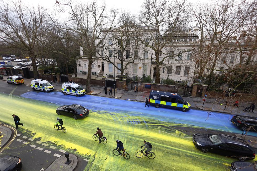 Police officers respond, after Protest group 'Led by Donkeys' spread paint in the colours of the Ukrainian flag on the road, ahead of the first anniversary of Russia's invasion of Ukraine, outside the Russian Embassy in London, Britain February 23, 2023. REUTERS/Hannah McKay