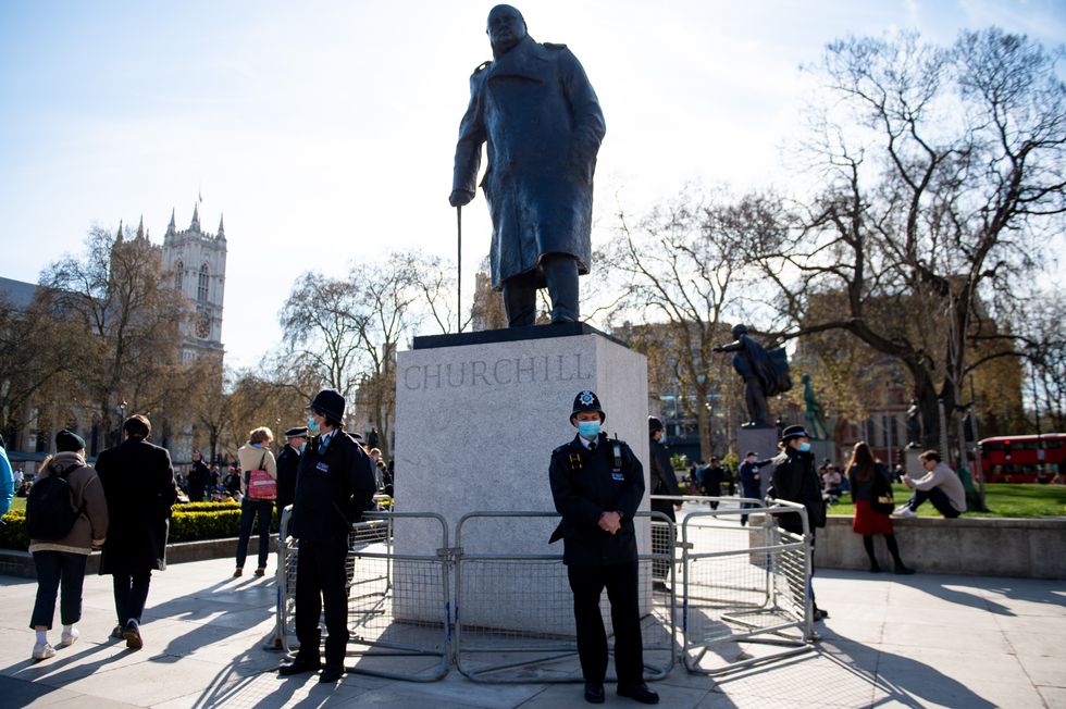 Police officers stand by a statue of Winston Churchill during a 'Kill The Bill' protest against The Police, Crime, Sentencing and Courts Bill in Parliament Square, London. Picture date: Saturday April 17, 2021.