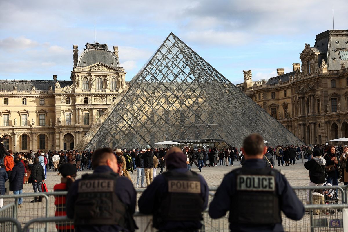 Police officers stand guard near the Louvre Pyramid in Paris