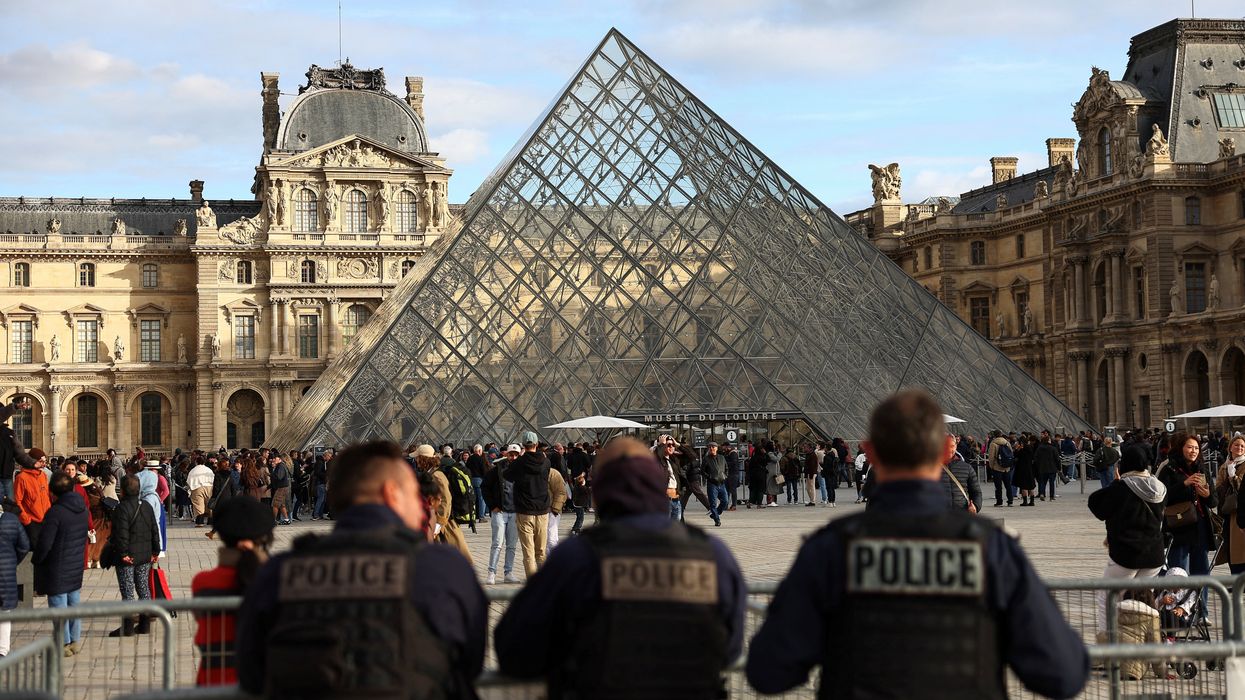 Police officers stand guard near the Louvre Pyramid in Paris