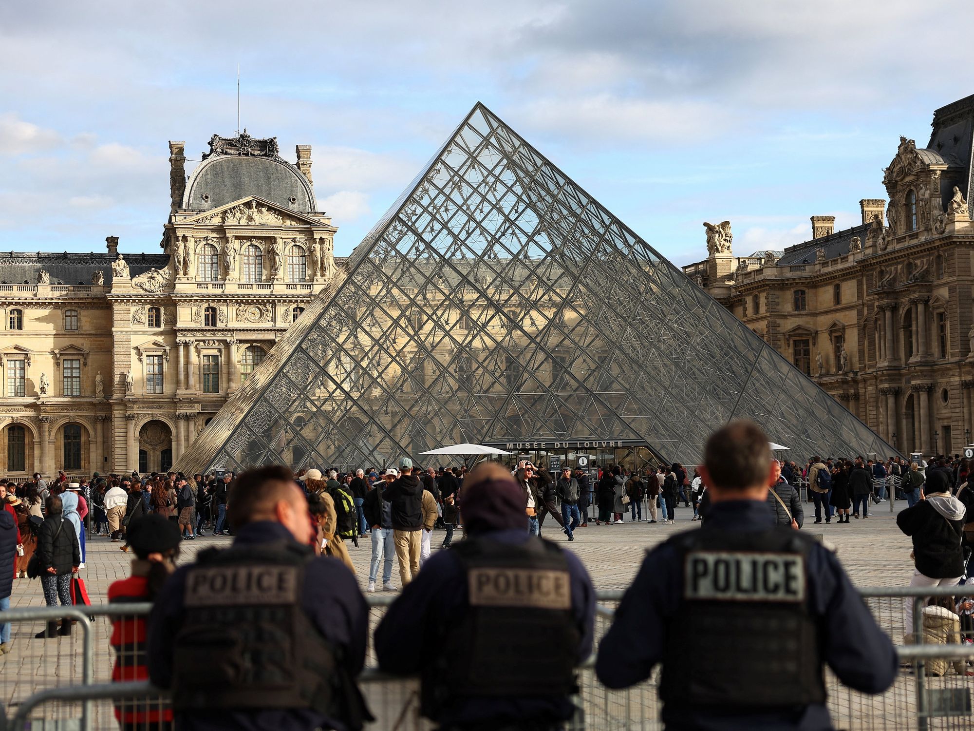 Police officers stand guard near the Louvre Pyramid in Paris