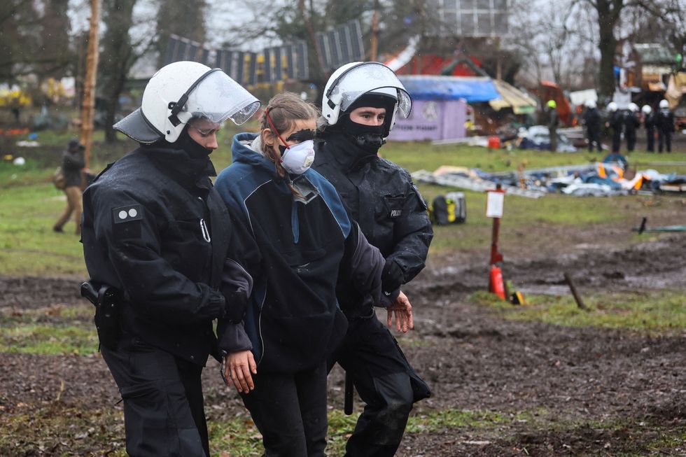 Police officers take away an activist during a sit-in protest against the expansion of the Garzweiler open-cast lignite mine of Germany's utility RWE, in Luetzerath, Germany, January 12, 2023 that has highlighted tensions over Germany's climate policy during an energy crisis. REUTERS/Wolfgang Rattay