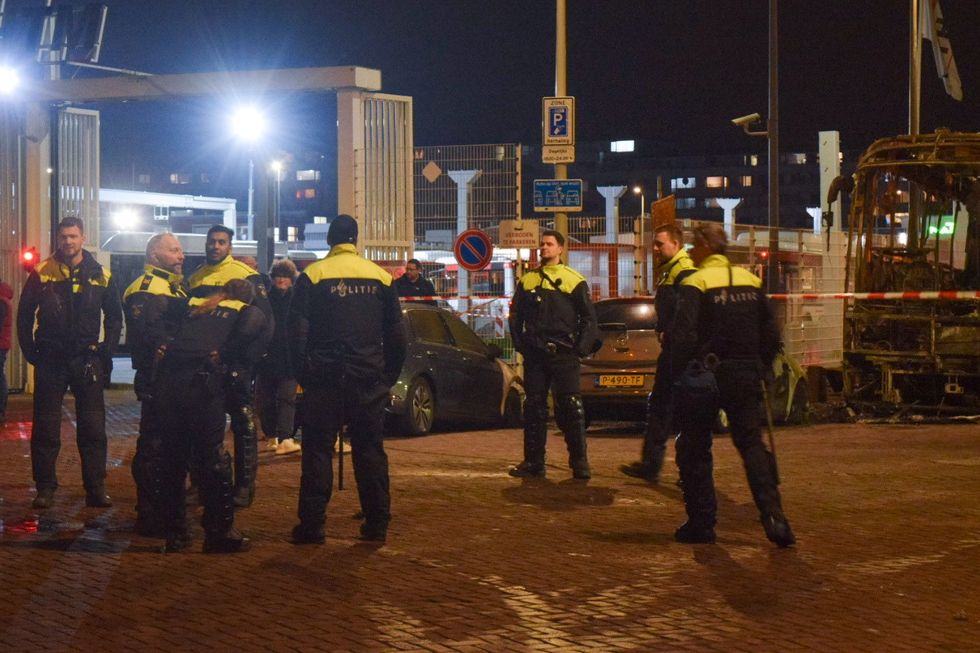 Police officers take security measures after vehicles were burned at the Opera hall center