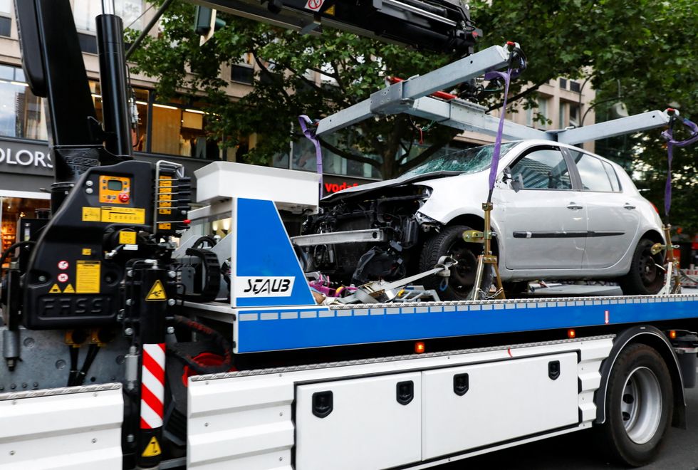 Police officers tow a car away at the scene where it crashed into a group of people near Breitscheidplatz in Berlin, Germany.