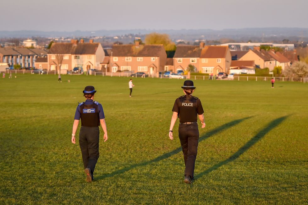 Police officers walking down a hilly bank