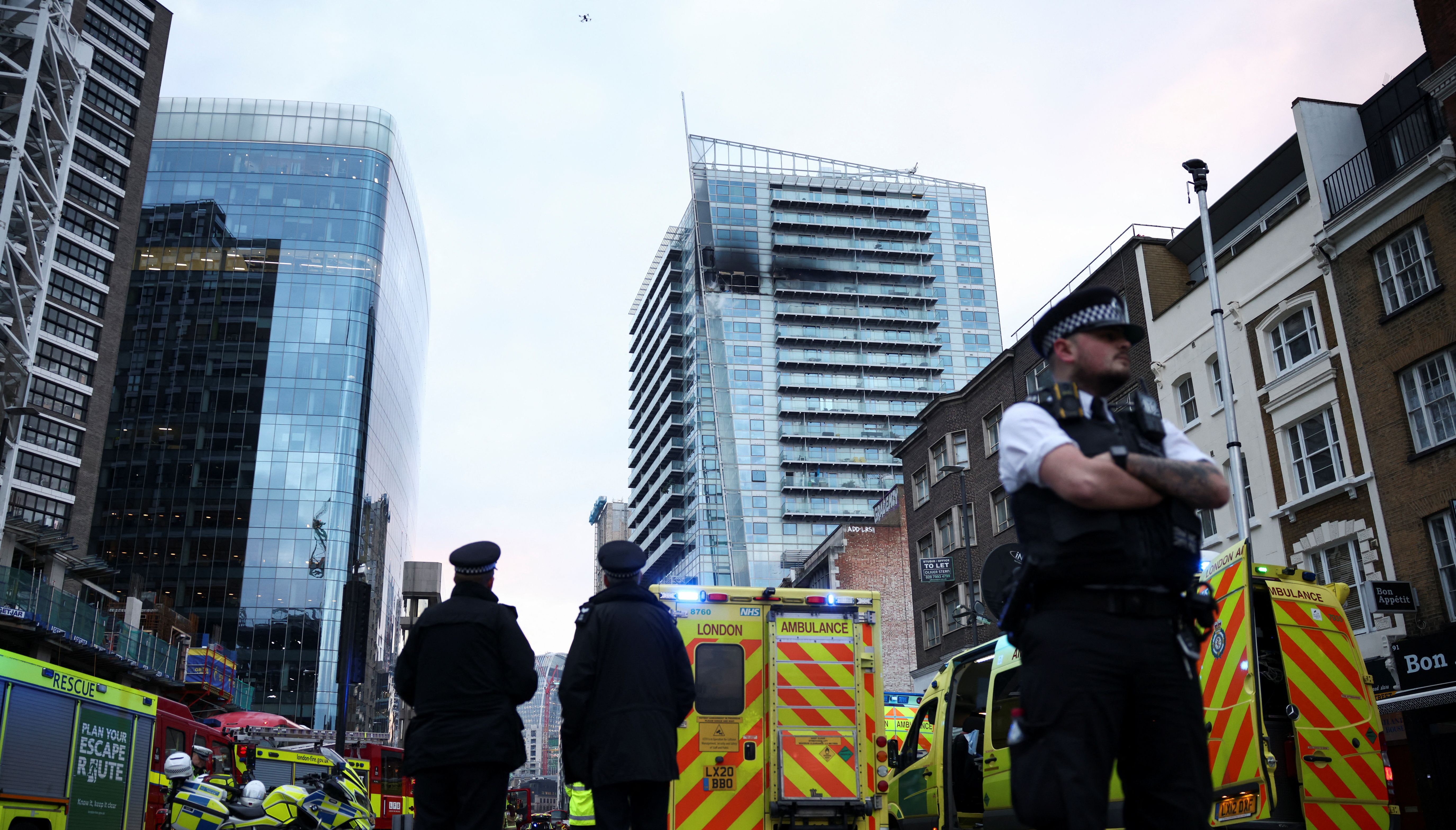 Police officers work at a fire site in East London, Britain, March 7, 2022. REUTERS/Henry Nicholls