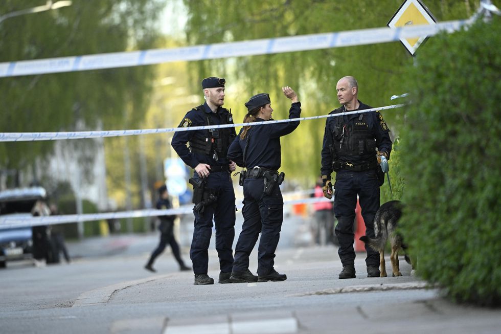 Police officers work near the scene where several people were injured after a series of loud bangs that indicated gunfire