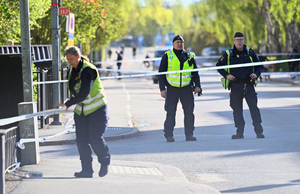 Police officers work on-site a day after a deadly shooting