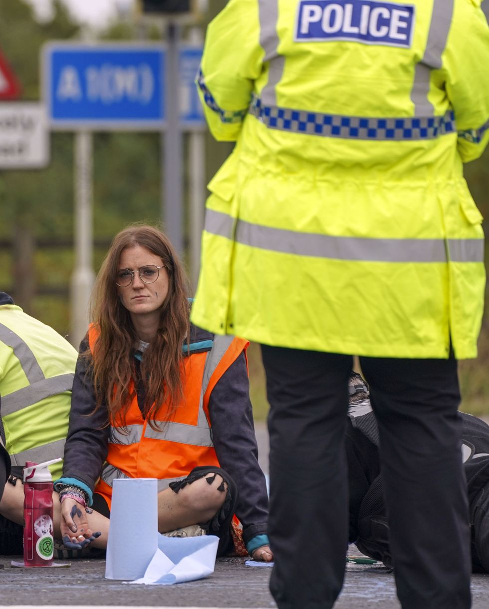 Police officers work to free protesters who had glued themselves to a slip road at Junction 4 of the A1(M), near Hatfield.